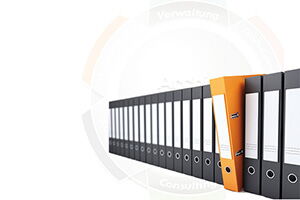 In einer Reihe voller schwarzer ordner ragt ein orangefarbener Ordner griffbereit heraus