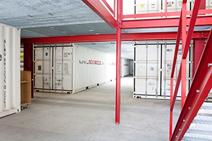 Ein Kreuzungspunkt in einem Lager voller weißer Container bei LAGER 3000